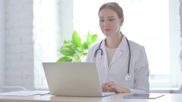 Lady Doctor Talking on Video Call on Laptop in Clinic