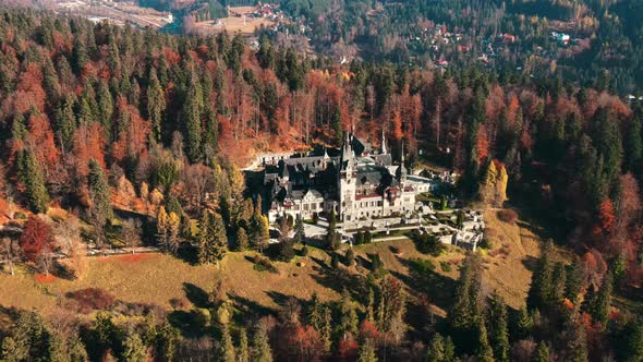 Aerial drone view of The Peles Castle in Romania. Castle with gardens in Carpathians, forest around 