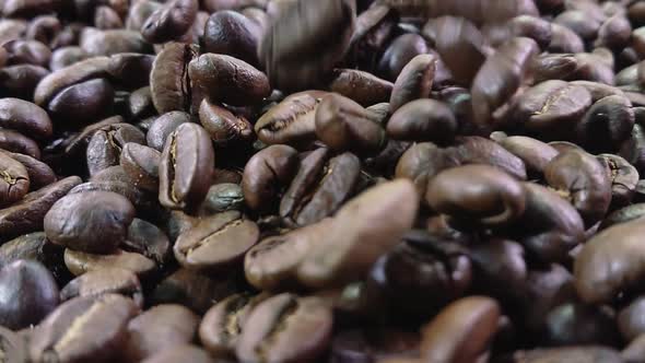 Closeup of Coffee Beans Bouncing and Rotating on Coffee Texture in Slow Motion