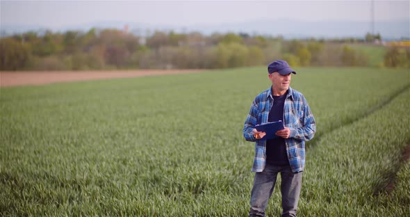 Thoughtful Male Botanist Writing On Clipboard. Farmer Examining Agriculture Field.