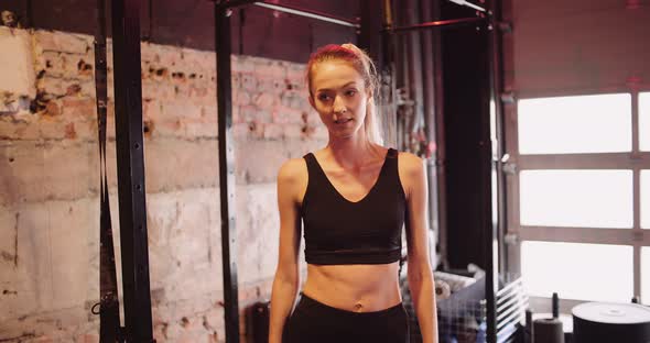 Young Woman Walking and Smiling While Exercising at Gym