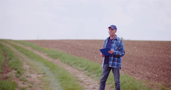 Thoughtful Male Botanist Writing On Clipboard