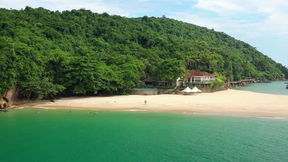 Aerial: island of pigs ubatuba brazil with view of the jungle and beach from the air and view of the