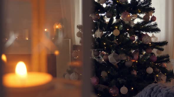 Burning Candles. Christmas Celebration in Cozy Interior with Decorated New Year Tree