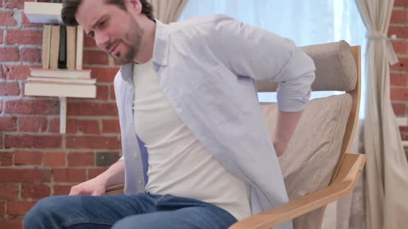 Casual Young Man Having Back Pain on Sofa