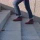 Female Legs in Burgundy Boots and Blue Jeans Climb the Stone Stairs - VideoHive Item for Sale