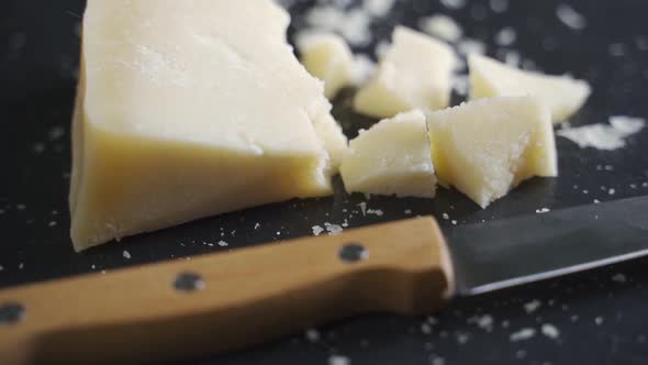 Hard Gourmet Parmesan Cheese on a Black Stone Plate. Plate Rotates, Close-up