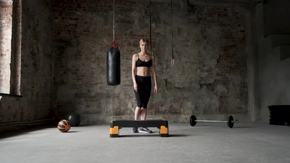 Woman doing step-up. Urban workout. Warming sport exercise