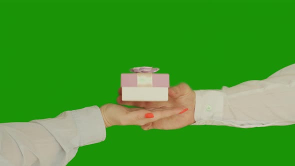 A man gives a woman a gift in a small box with a bow, chroma key