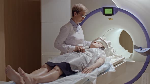 Radiologist Moving Patient into MRI Machine