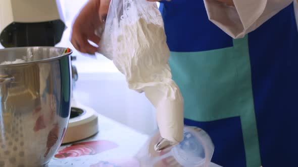 A Woman Chef Fills a Bag for Cream with a Patterned Nozzle with Snowwhite Cream