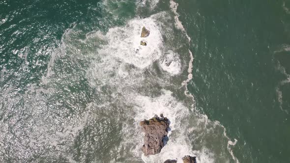 Aerial top down view sea surface reveal Nazaré Lighthouse viewpoint on Cliff Premonitory