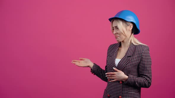 Beautiful Blonde Mature Woman Recommends a Product on the Left Side Wears an Engineer's Helmet on