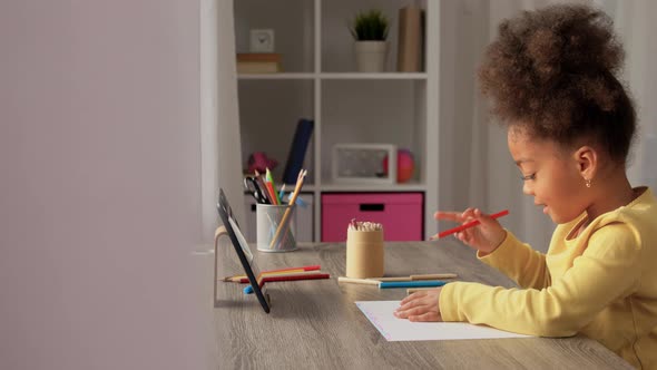 Little Girl Drawing with Coloring Pencils at Home