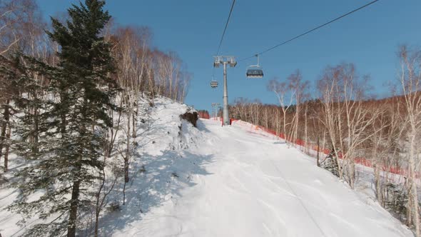 Riding on Ski Lift Above the Slopes in the Morning