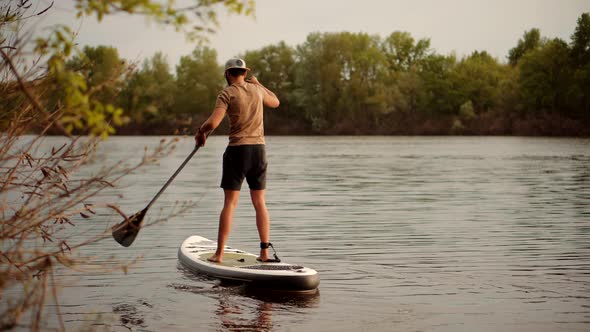 Tourist Floating Sup Board On Vacation. Tourist Floating Standup Paddle Board. Man Swim Surfing Boat