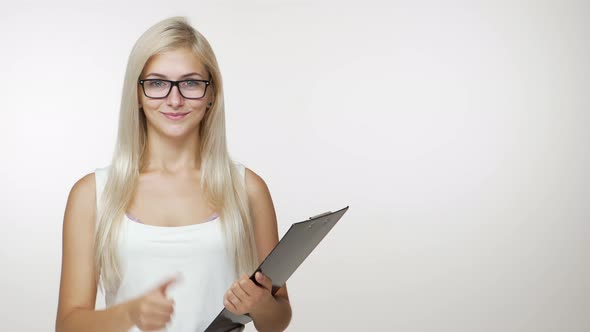 Copy Space Succeed Businesslady with Blond Hair in Glasses Smiling Holding Clipboard Showing Thumb