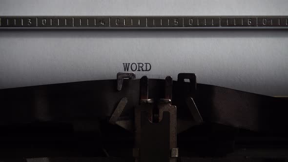 Typing word on retro typewriter. Close up.
