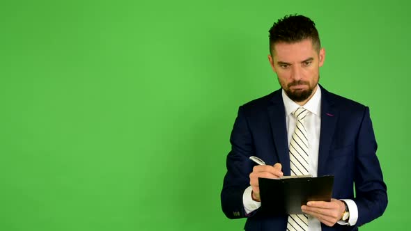 Business Man Writes To Paper (Serious Face) - Green Screen - Studio