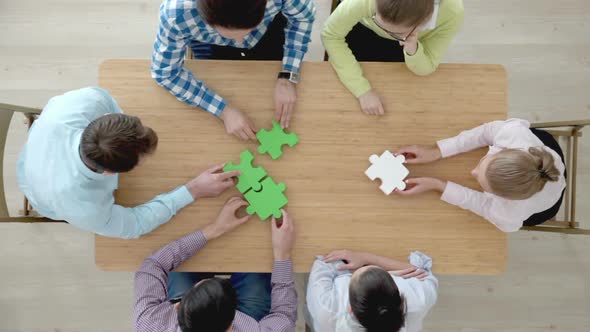 People Assembling Jigsaw Puzzle