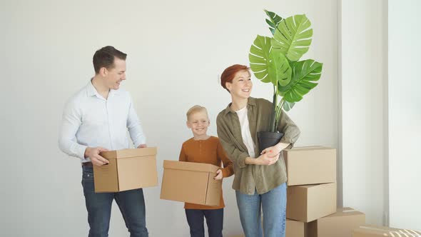 Mortgage Family and Real Estate Concept Happy Mother Father and Little Son with Stuff in Boxes