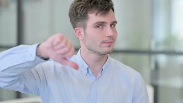 Portrait of Thumbs Down Gesture By Young Man