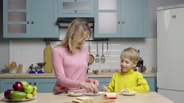 Woman Teaches Boy How to Make Sandwiches By Buttering Bread