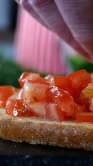Chef Sprinkles Toasted Bread and Finely Chopped Red Tomatoes with Sliced Dill to Make a Sandwich