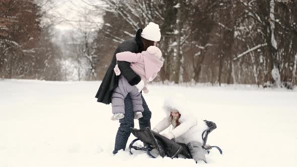 Mother Having Fun Sledding with Kids in Winter Forest