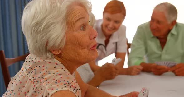 Senior woman talking to senior man while sitting at dinning table