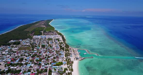 Wide angle birds eye travel shot of a white sandy paradise beach and aqua blue water background in b