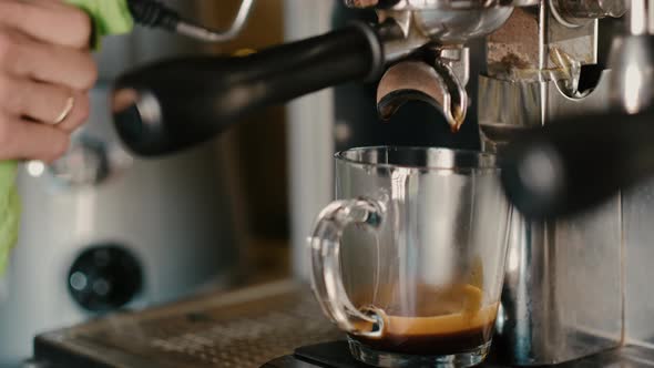 Process of making espresso in a coffee machine. Barista making latte in  specialty coffee shop.