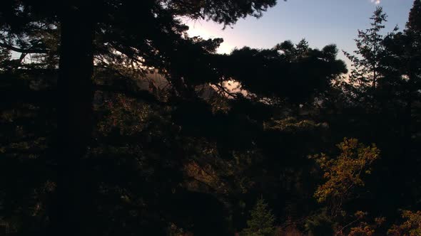 Aerial view of the sun setting on a beautiful mountainside in the fall