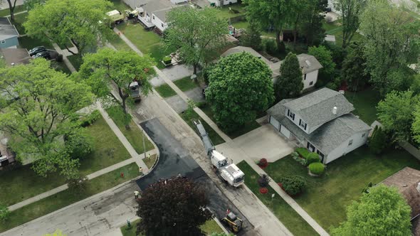 Aerial Drone View of Road Repairs in the Suburbs on the Street with Many Houses Laying of New