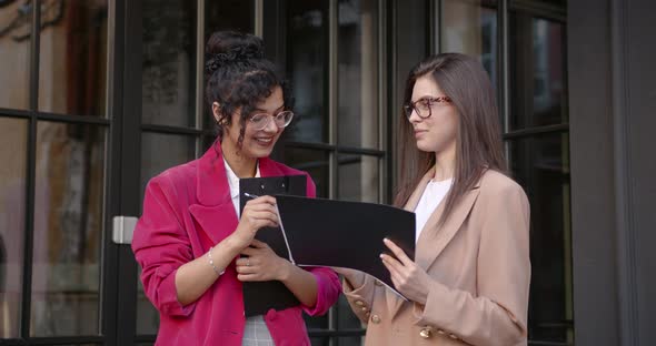 Multi Ethnic Girls Working in Cafe with Papers