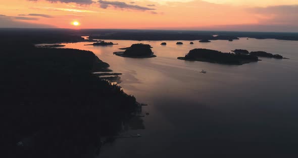 Aerial shot at sunset over lake with islands. Slow, forward moving tracking shot.