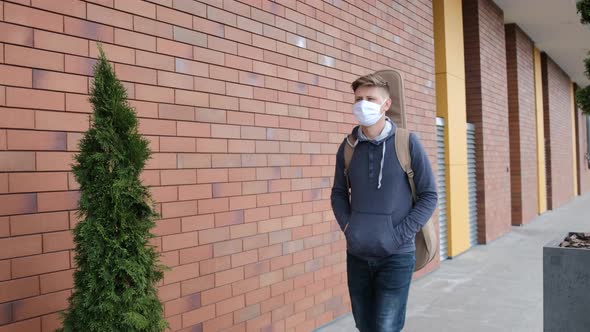 Guitarist with a Guitar in the Back Walking Outside with a Medicinal Mask on Face