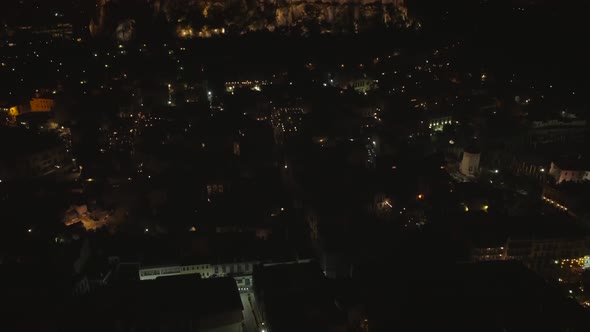 Aerial view of the parthenon temple on acropolis hill at night in Athens.