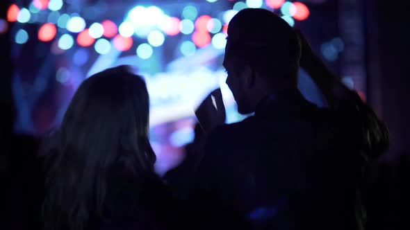 Happy Woman and Man Waving Hands and Dancing at Music Festival, Nightlife