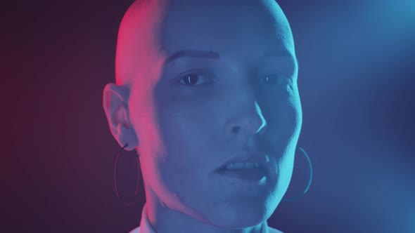 Portrait of Woman with Shaved Head in Neon Light