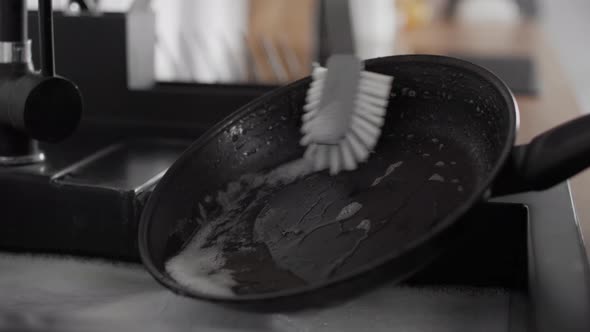 Close up of caucasian woman washing frying pan. Shot with RED helium camera in 8K.
