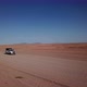 Car Driving on Gravel Road in Aerial Desert - VideoHive Item for Sale