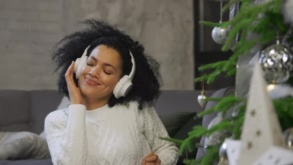Portrait of a Happy African American Woman Listening to Music with Big White Headphones