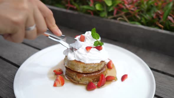 Close Up of Two Gluten Free Pancakes with Plant Based Whipped Cream Being Cut with Cutlery