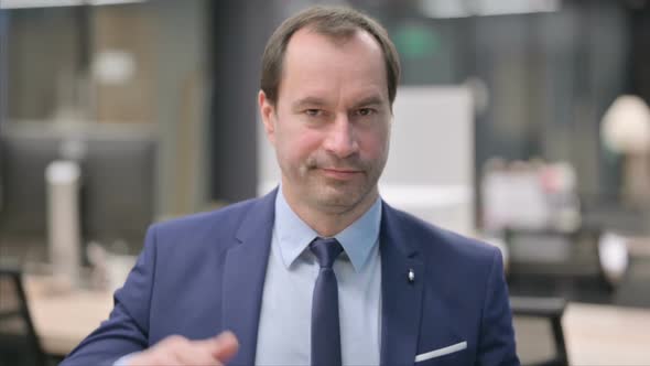 Portrait of Businessman Showing Thumbs Down Gesture