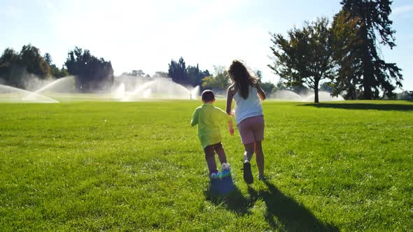 Children playing in city park full of sprinklers