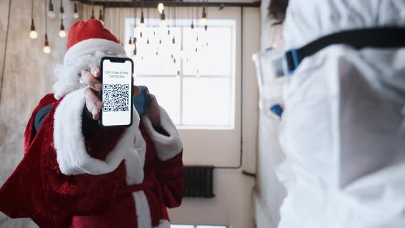 Santa Claus in Red Costume Shows QR Code Before Visiting the Christmas Party