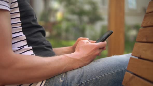 Man Is Typing a Message on His Mobile Phone