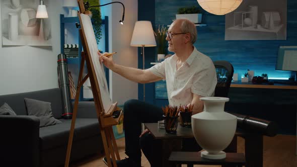 Senior Adult Using Pencils to Draw Vase on White Canvas