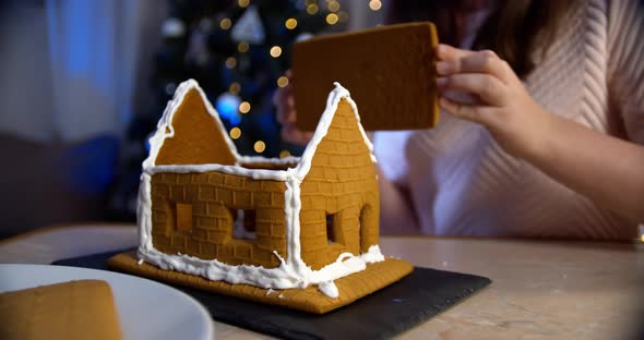 Woman Decorate Gingerbread House